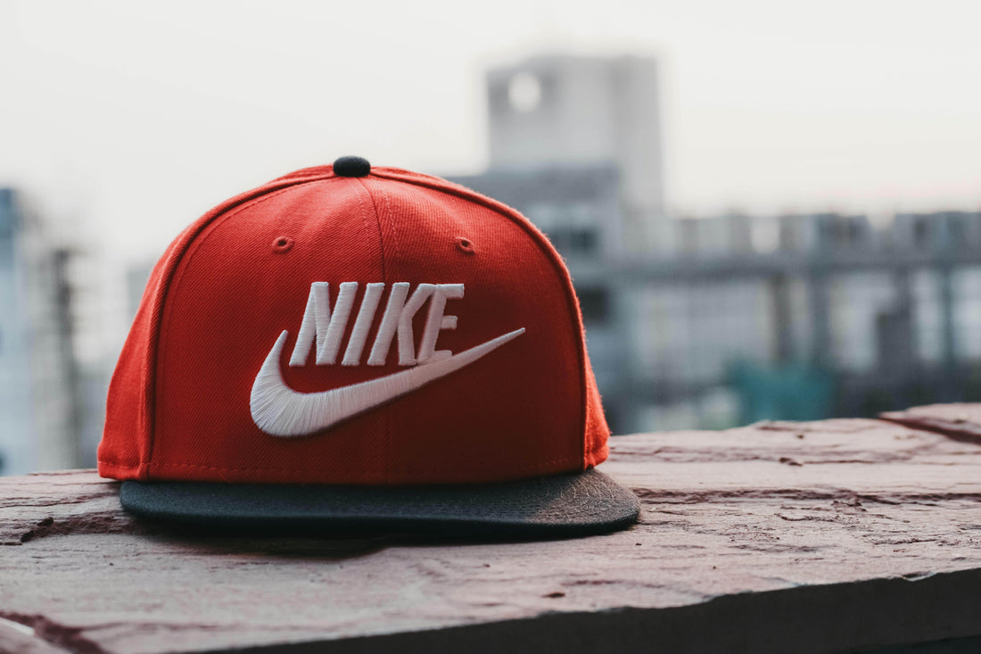 Red Baseball cap with Nike logo laying on a mural - How to Wash your Cap Without Ruining It - Re:claim Washing Detergent